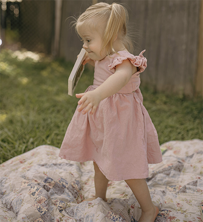 Evangeline Fury walking on blanket outside with book