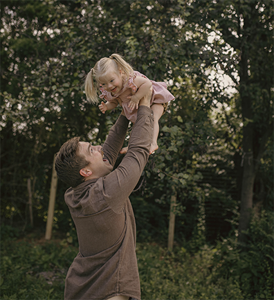 Clayton Fury lifting daughter Evangeline up high above his head as she laughs