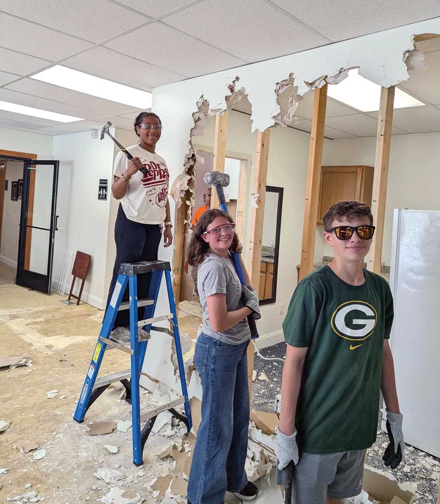 Volunteers from Mount Calvary, Harrison, Wis., helping Ascension, Crossville, Tenn. green bay shirt sledge hammer