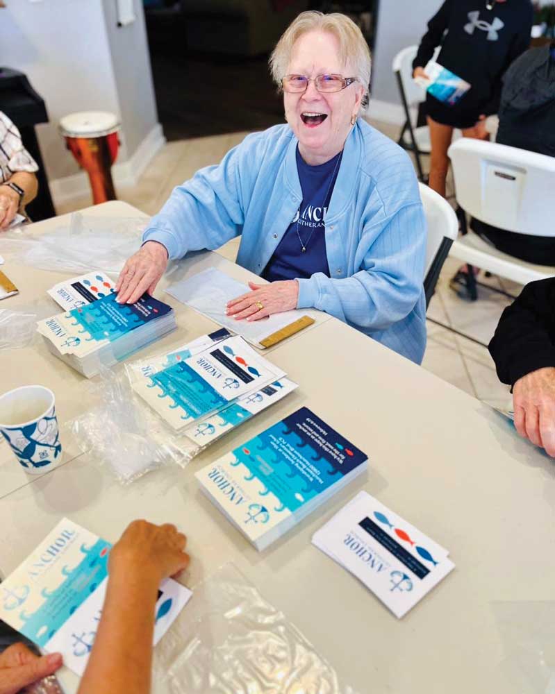 Assembling invitations for prospects at Anchor, Panama City Beach, Fla Older lady wearing blue