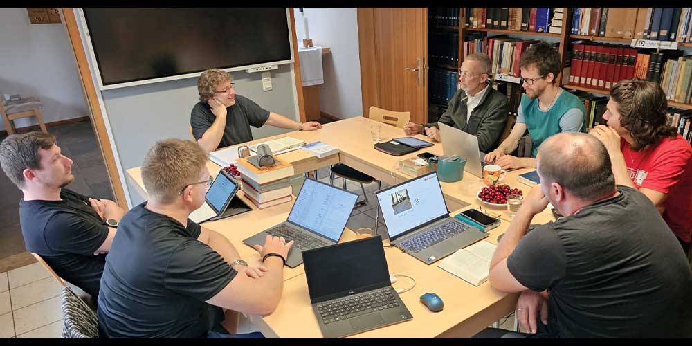 men sitting around a table on their computers