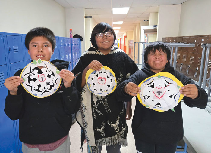 three kids holding wels seal drawings