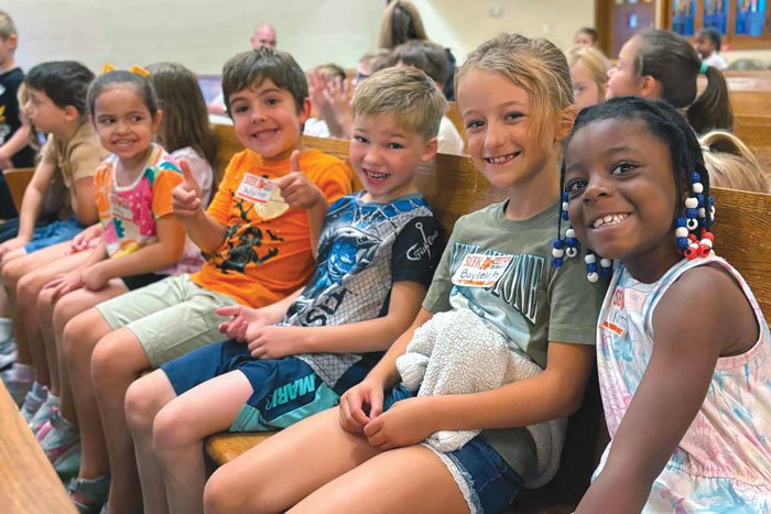 small children in church pew smiling