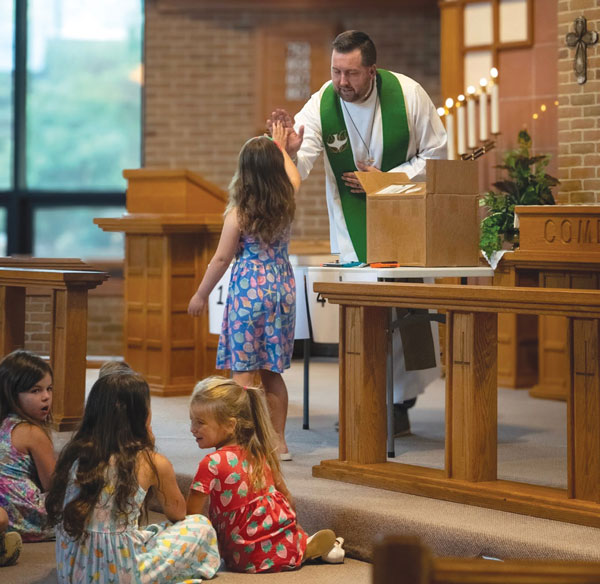 pastor giving a girl a high five in church