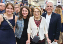 Bethel Zabell using a walker and three generations of students