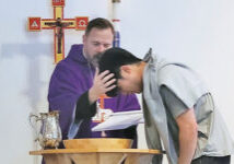 boy being baptized by pastor wearing purple