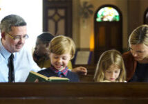 Parents and children in church sitting in pew