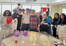 young adults eating cupcakes holding balloons