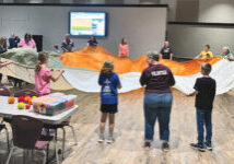 kids and adults playing with a large parachute