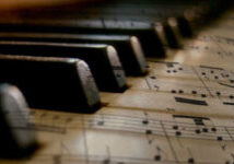 close up of piano keys and music sheets